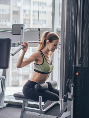 Genç kız spor salonunda egzersiz yapıyor.