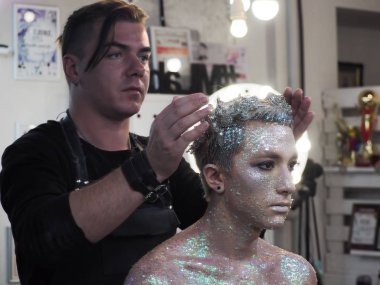 Makyaj sanatçısı genç erkek model de taç koyar 