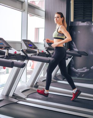 Genç kız spor salonunda egzersiz yapıyor.