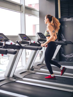 Genç kız spor salonunda egzersiz yapıyor.