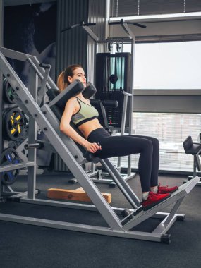 Genç kız spor salonunda egzersiz yapıyor.