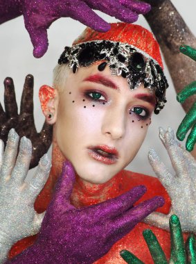 Kırmızı sanat makyajı nda yeşil gözlü adam modeli ne bakıyor