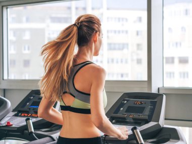 Genç kız spor salonunda egzersiz yapıyor.