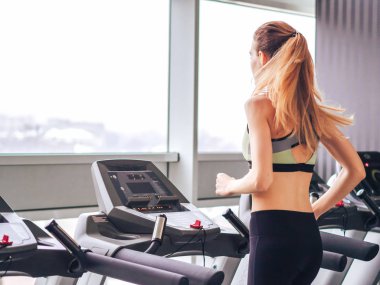 Genç kız spor salonunda egzersiz yapıyor.