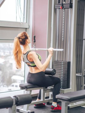 Genç kız spor salonunda egzersiz yapıyor.