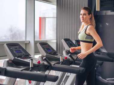 Genç kız spor salonunda egzersiz yapıyor.