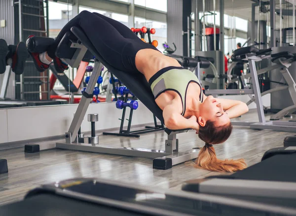 Chica joven hace ejercicios en el gimnasio — Foto de Stock