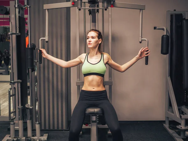 Молодая девушка делает упражнения в спортзале — стоковое фото