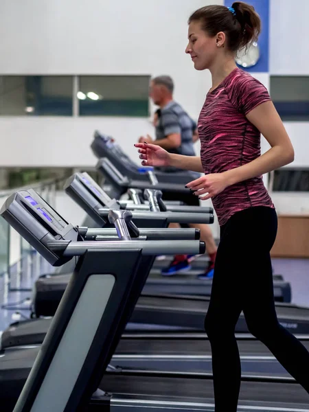 Young model girl makes exercises at the gym in front of mirror — Stock Photo, Image