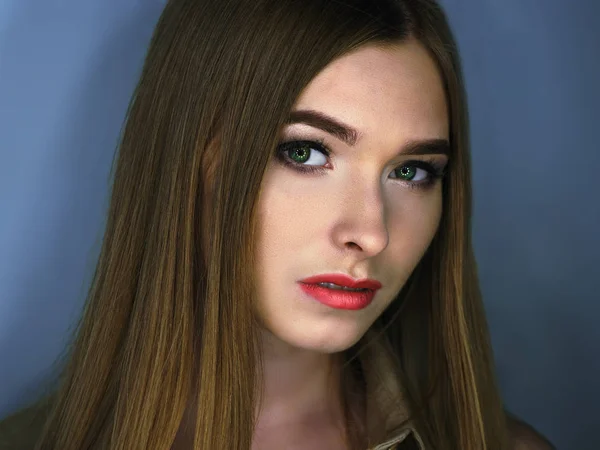 Ung flicka med röda läppar och gröna ögon tittar på kameran — Stockfoto