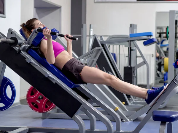 Chica modelo joven hace ejercicios en el gimnasio frente al espejo — Foto de Stock