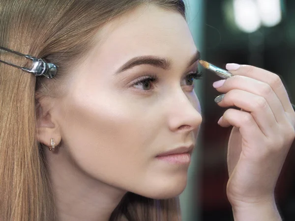 Mladá dívka make-up a pohled na zrcadlo close-up — Stock fotografie