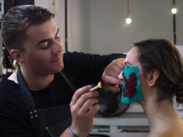 Výtvarník make-up dělá umělecké dílo v modelech tváře — Stock fotografie