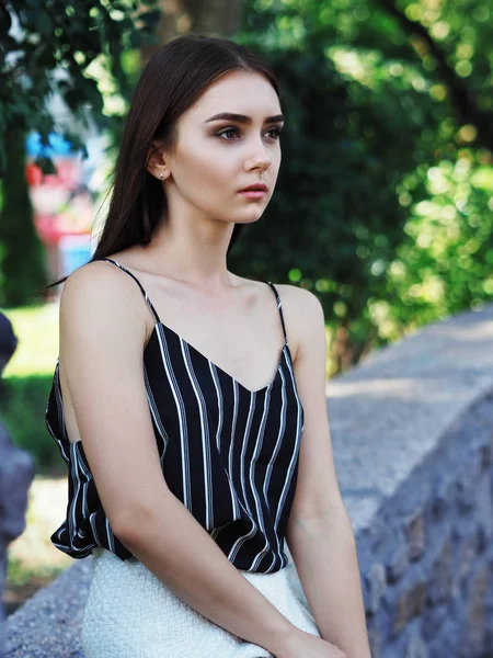 Chica joven modelo posando en el parque sentado —  Fotos de Stock