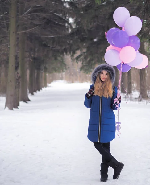 Chica joven en el abrigo azul con globos en el bosque —  Fotos de Stock