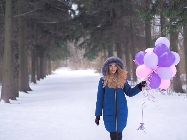 Chica joven en el abrigo azul con globos en el bosque —  Fotos de Stock