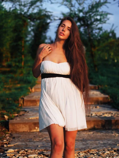 Joven modelo morena en el vestido blanco que se queda en las escaleras wi —  Fotos de Stock