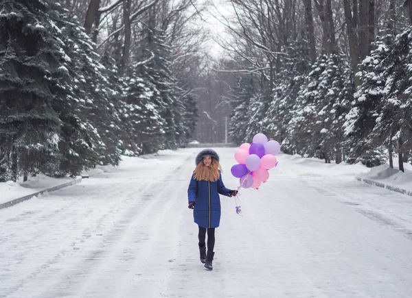 在森林里穿着蓝色外套、拿着气球的小女孩 — 图库照片