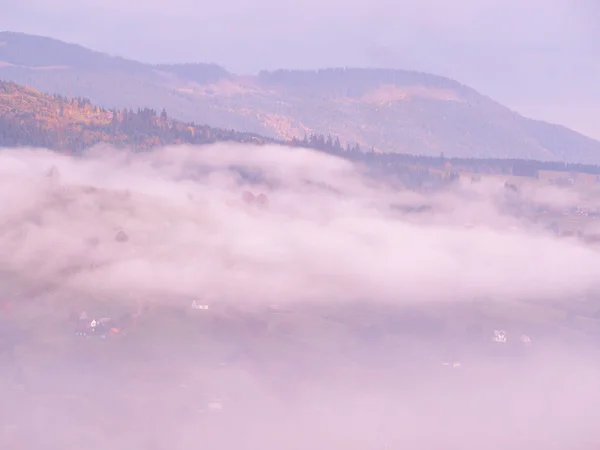 Carpatian pueblo en las montañas en el soleado día de niebla — Foto de Stock