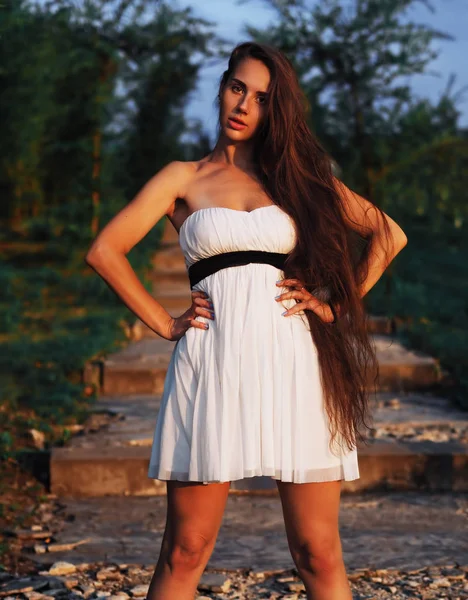 Joven modelo morena en el vestido blanco que se queda en las escaleras wi —  Fotos de Stock