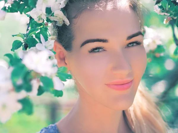 Portret van het jonge meisje aan de witte lente bloemen bloesem — Stockfoto