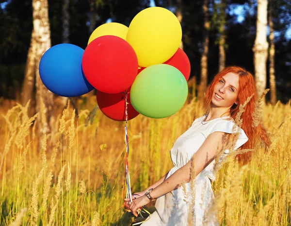 Meisje Redhead staande met ballons op de gele aartjes — Stockfoto