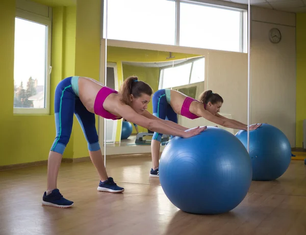 Jong model meisje maakt oefeningen in de sportschool in de voorkant van spiegel — Stockfoto