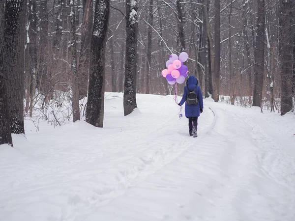 在森林里穿着蓝色外套、拿着气球的小女孩 — 图库照片