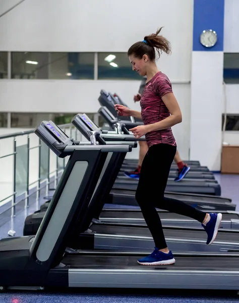 Jovem modelo menina faz exercícios no ginásio na frente do espelho — Fotografia de Stock