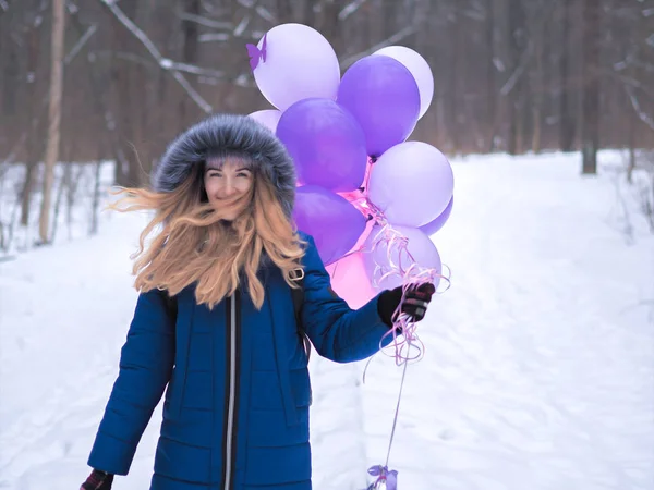 Chica joven en el abrigo azul con globos en el bosque —  Fotos de Stock