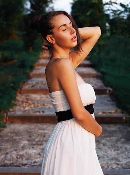 Młoda brunetka model w białej sukience zatrzymując się na schodach wi — Zdjęcie stockowe
