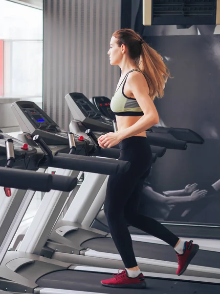 Genç kız spor salonunda egzersiz yapıyor.