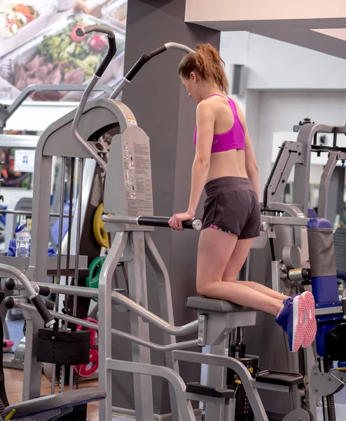Jovem modelo menina faz exercícios no ginásio na frente do espelho — Fotografia de Stock