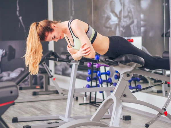 Chica joven hace ejercicios en el gimnasio — Foto de Stock