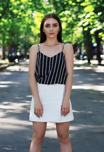 Chica joven modelo posando en el parque mirando hacia adelante —  Fotos de Stock
