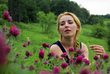 çiçekler içinde oturan güzel genç kadın portresi