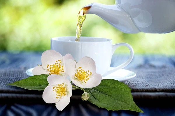 jasmine tea and jasmine flowers on wooden background