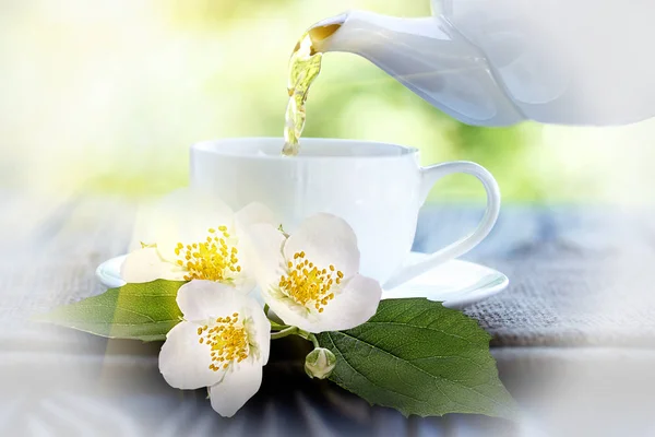 jasmine tea and jasmine flowers on wooden background