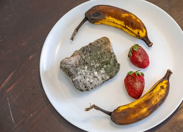 Şımarık, eski küflü yiyecekler beyaz yuvarlak tabakta.