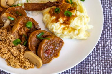 Geleneksel kırsal Brezilya yemeği, Madeira soslu sığır dili, mantar, pirinç, farofa ve patates püresi.