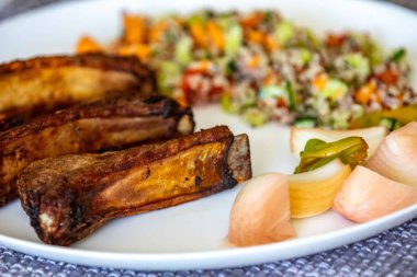 Besin, kızarmış domuz pirzolası, manyok, kinoa, salata ve sebzelerle dengelenmiş sağlıklı süper yiyecekler. Gerçek yemek.