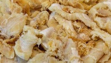 Tuzlanmış ve kurutulmuş, yuvarlak beyaz bir tabakta, gadus makrosefalus morina filetosu parçaları.