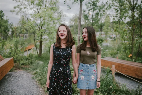 Две девушки держатся за руки и смеются — стоковое фото