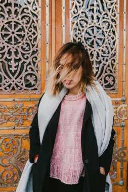 Sokakta ceket yüzünde rüzgar saçlı kız