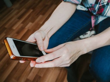 bir cep telefonu tutan kız elinde