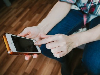 bir cep telefonu tutan kız elinde