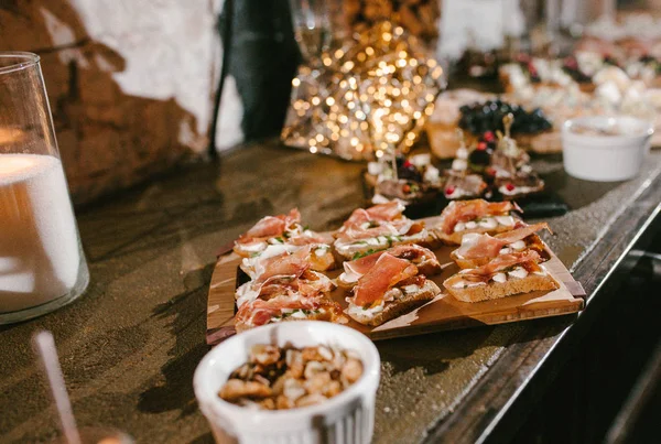 Aperitivo con jamón y queso mozzarella sobre pan —  Fotos de Stock