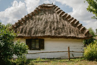 bir saman çatı ve bahçe ile eski ahşap ev
