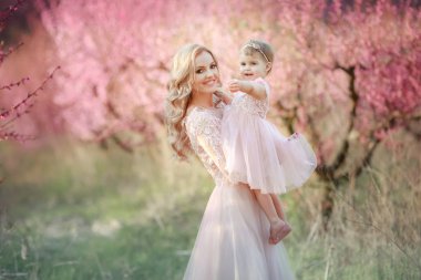 Gül bahçesinde çiçekler ağaçlar bulunan bir bebek ile anne