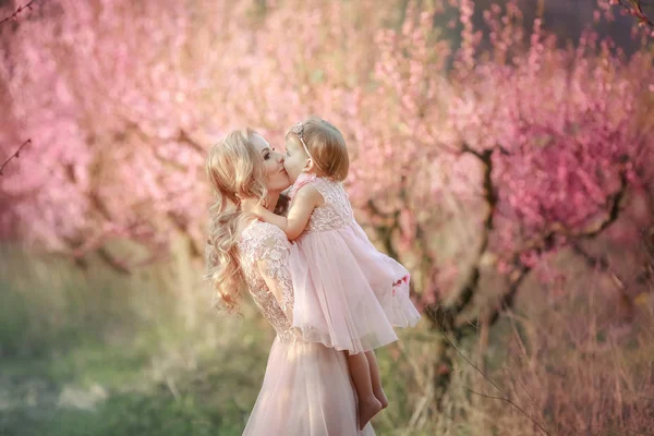 Mom with an infant in the rose garden with flowers trees — Stock Photo, Image